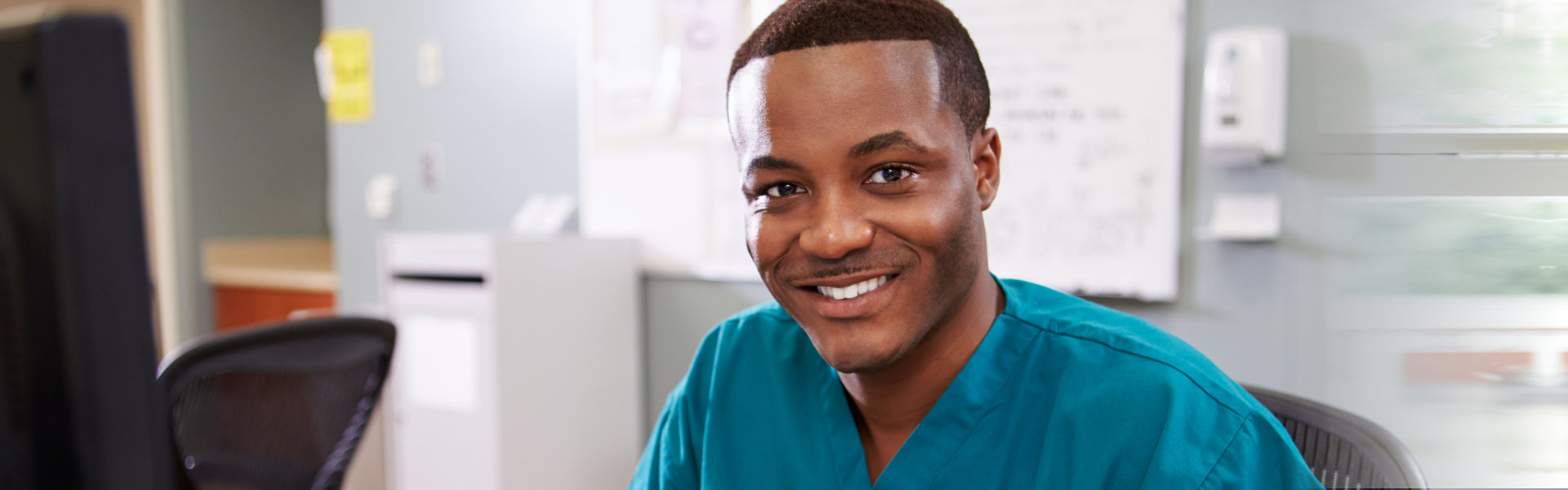 caregiver smiling wearing blue green shirt